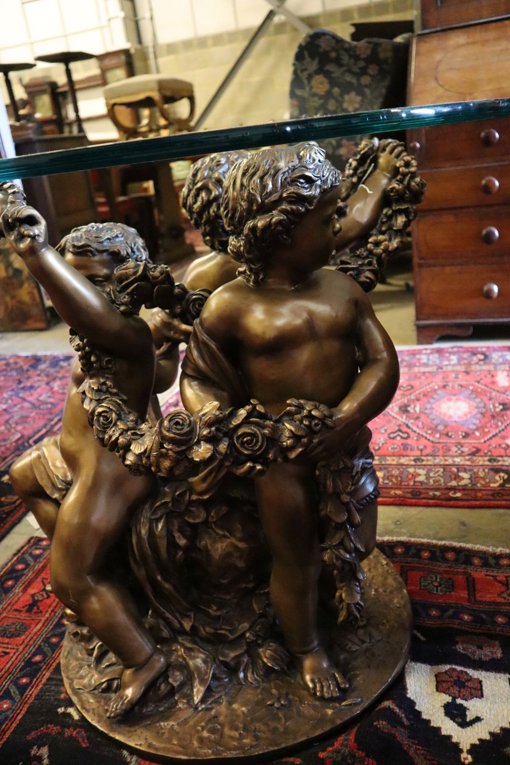 A cast gilt metal glass top cherub centre table, 81cm diameter
